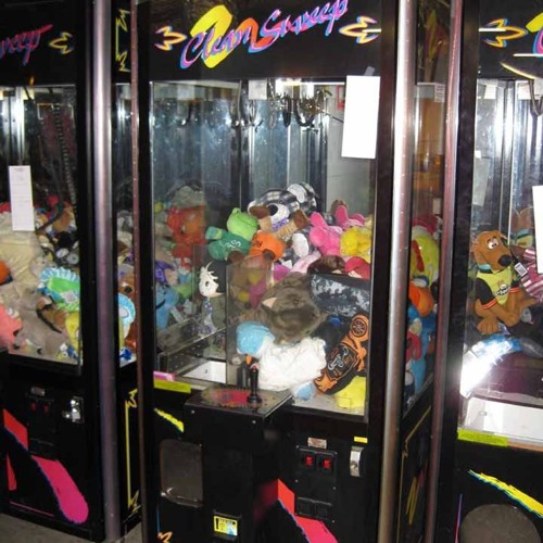 Playing A Claw Machine In A Seedy Casino Arcade