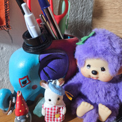 a yarn-bombed tree with pom-poms