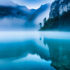 The azure lake enveloped in a transparent veil of mist