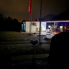Lonely  Gas station at night some wind ratling metal air condition dogs distant