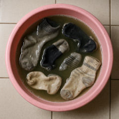 Une bassine de matière plastique rose dans laquelle croupissent six chaussettes